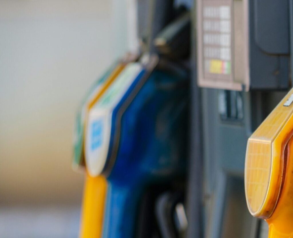 Close-up of vibrant fuel nozzles at a gasoline station showcasing diesel, gas, and petrol options.