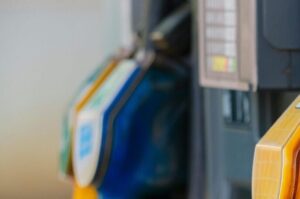 Close-up of vibrant fuel nozzles at a gasoline station showcasing diesel, gas, and petrol options.